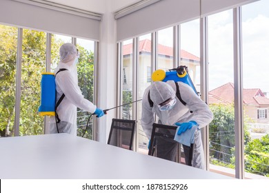 Two Asian Men Are Disinfecting An Office Building. Big Cleaning Day. Background And Copy Space.