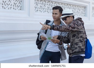 Two Asian Men Travelers Looking Map At A Temple ,what Are The Attractions Location In The Map.