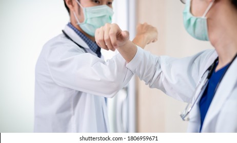 Two Asian Professional Doctors Greeting Each Other With Touching Or Bumping Elbows Instead Of Handshake, Hug Or Kissing To Avoid The Spread Of Coronavirus. COVID-19 Alternative Handshake.