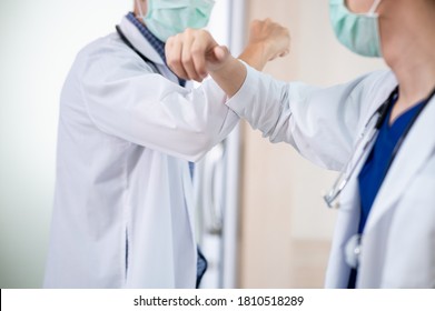 Two Asian Professional Doctors Greeting Each Other With Touching Or Bumping Elbows Instead Of Handshake, Hug Or Kissing To Avoid The Spread Of Coronavirus. COVID-19 Alternative Handshake.