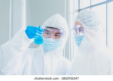 Two Asian Scientist Team Reserch Chemistry Science Tube Experiment Biotech Antibody Sample In Laboratory Cultivate Vaccine Against Covid-19 Virus. Scientist Consult, Analyze In Chemistry Laboratory