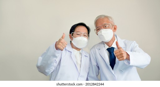 Two Asian Senior Doctors Scientist With Mask Show Successful Victory Over Covid-19 Gesture Happy Results