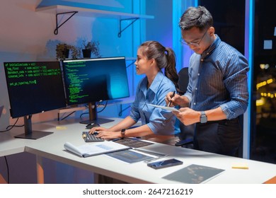 Dois engenheiros de software asiáticos colaboram à noite em escritórios modernos, escrevendo algoritmos de aprendizado de máquina e depurando código de inteligência artificial em vários monitores no fluxo de trabalho de desenvolvimento tecnológico de IA.