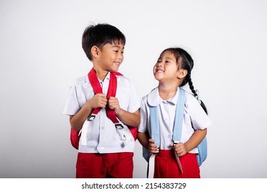 Two Asian student kid girl boy schoolchildren brother sister smile happy wear student thai uniform red pants skirt in studio shot isolated on white background, Portrait little children girl preschool - Shutterstock ID 2154383729