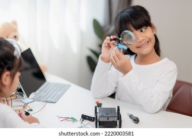 Two Asian students learn coding robot cars and electronic board cables in STEM, STEAM, mathematics engineering science technology computer code in robotics for kids concepts.