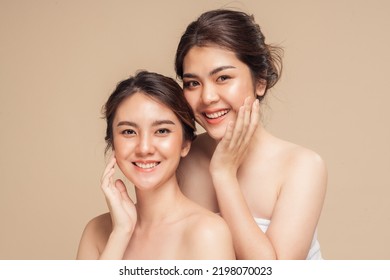 Two Asian woman with beauty face touching healthy skin care. Beautiful female models happy smiling with perfect face skin and natural makeup on beige background. Spa skin care concept. - Shutterstock ID 2198070023