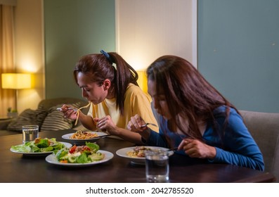 Two Asian Woman Friends Having Dinner Eating Pasta And Salad With Talking Together At Home. Attractive Female Girlfriends Relax And Enjoy Indoor Lifestyle Activity And Holiday Celebration Together