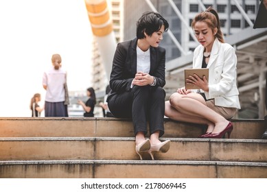 Two Asian Woman Talking Business Partners Using Digital Tablet Smartphone Meeting Outside Office At Street City. Teamwork Partnership Women Talking Discuss At Outdoor Office Partnership Team Advice.