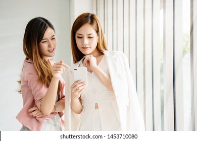 Two Asian women businessmen are discussing the 5 G system that will come into play with people in the modern era, what to use. And how fast the transfer of numbers in investment in debt of fast - Powered by Shutterstock