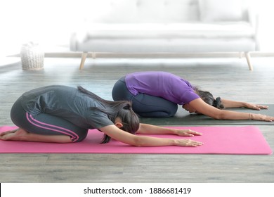 Two Asian Women Lay On Yoga Exercise Mat Practice Stretching. Home Exercise Fitness Class Clam And Relaxation Concept. Copy Space. 