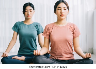 Two Asian women are practicing meditation at home
 - Powered by Shutterstock