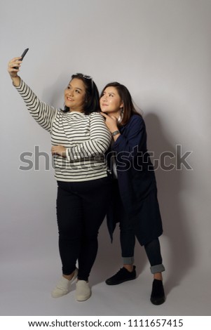 Similar – Image, Stock Photo funny twin sisters make a selfie with the smartphone