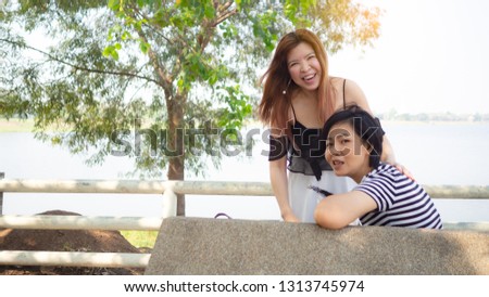 Two Asian women Talk, tease, play in public park have long hair and short, 
She is both beautiful and cute. Concept Cute girl friend or lesbian couple.