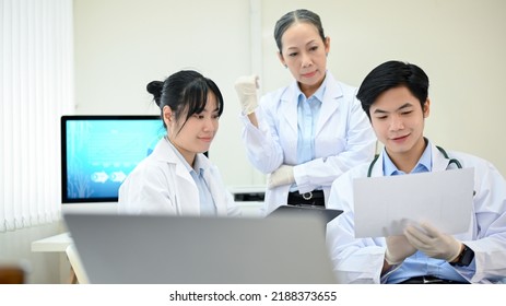 Two Asian young scientist or medical technician working, having a medical discuss meeting with an Asian senior female scientist supervisor in the laboratory. - Shutterstock ID 2188373655