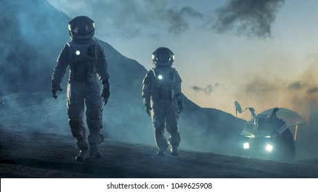 Two Astronauts in Space Suits Confidently Walking on Alien Planet, Exploration of the the Planet's Surface. In the Background Research Base/ Station and Rover. Space Travel, Colonization Concept. - Shutterstock ID 1049625908