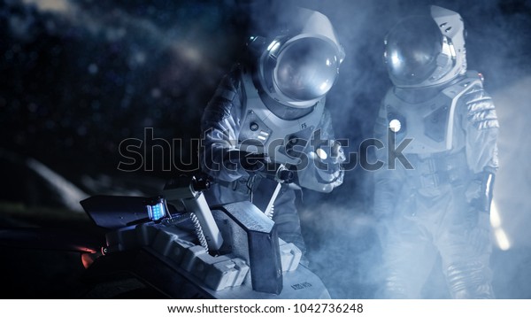 Two Astronauts in Space\
Suits on an Alien Planet Prepare Space Rover for Planet\'s Surface\
Exploration Expedition. Space Travel and Solar System Colonization\
Concept.