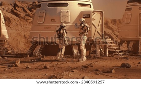 Two astronauts in spacesuits walk toward research station, colony or scientific base on Mars. Manned exploring space mission on red planet. Futuristic colonization and space exploration concept.