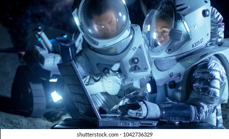 Two Astronauts Wearing Space Suits Work on a Laptop, Exploring Newly Discovered Planet, Communicating with the Earth. Space Travel, Exploration and Colonization Concept. - Shutterstock ID 1042736329