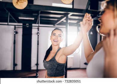 Two Athlete Woman Giving High Five In The Gym.