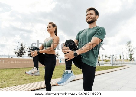 Two athletes doing leg stretches after a run, promoting fitness and wellbeing.
