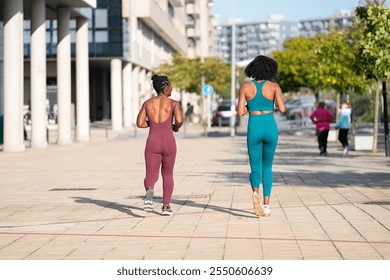 Two athletes jogging together on a paved road in an urban environment, promoting a healthy and active lifestyle - Powered by Shutterstock