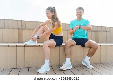 Two Athletes Preparing for a Workout on Wooden Benches in Bright Sunlight by the Waterfront - Powered by Shutterstock