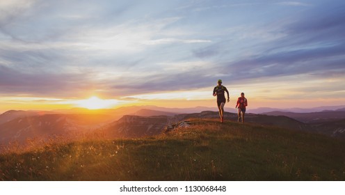 Two athletes trailrunning in the mountains during a nice sunset. Shallow D.O.F. and old film effect. - Powered by Shutterstock