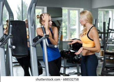 Two athletic blond women talking in the gym. Girl communicates with the trainer - Powered by Shutterstock