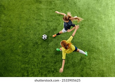 Two athletic women, mid-20s, locked in fierce duel over ball, showcasing agility and skill, each fighting for dominance on soccer field. Aerial view. Concept of sport, competition, tournament, games - Powered by Shutterstock