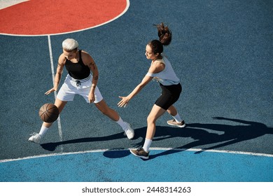 Two athletic young women stand triumphantly atop a basketball court in the summer sun. - Powered by Shutterstock