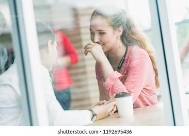 Two Attractive Caucasian Gossip And Conversation After Work Near Window And Desk Office Background