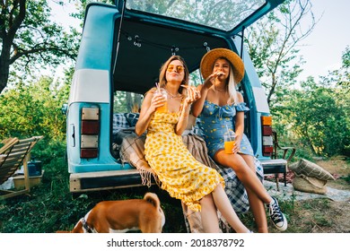 Two Attractive Cheerful Women Drinking Lemonade Near Van And Eating Pizza, Enjoying Summer Vibes In Road Trip