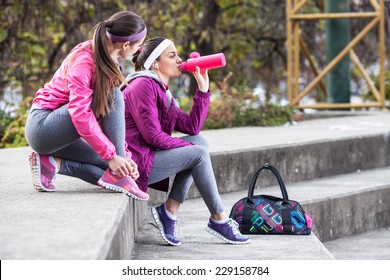 Two attractive female sitting and preparing for jogging.