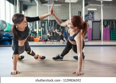 Two attractive fitness girls doing push ups