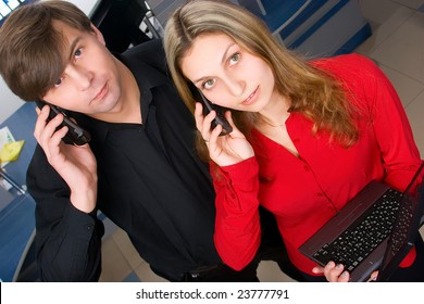 Two attractive managers talking by cellphones