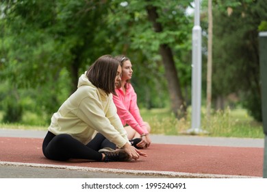 Two Attractive Yong Girl Friends Are Stretching Before Their Morning Training