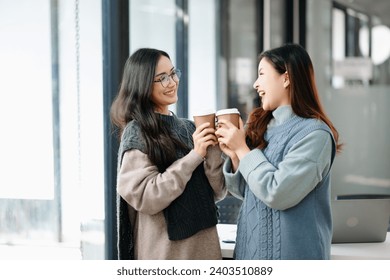 Two Attractive young Asian female college students working on the school project using laptop computer and tablet together, enjoy talking and snacking  - Powered by Shutterstock