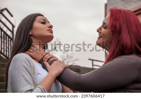 Two attractive young woman is having a harsh debate on the city street. Women fight
