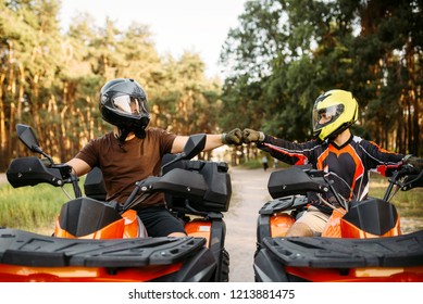 Two atv riders hits fists for good luck, back view