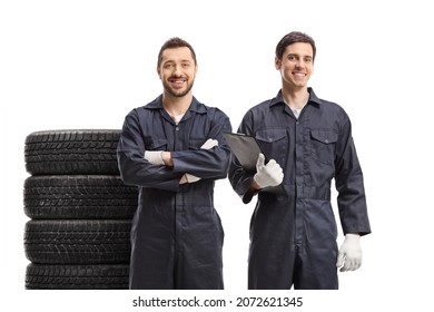 Two Auto Mechanic Workers In Uniforms With Car Tires Isolated On White Background