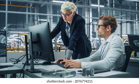 Two Automotive Engineers Discussing Concept Car Blueprints On Desktop Computer In Modern Office At Assembly Plant. Female Industrial Project Manager Talk To Male Designer At Vehicle Factory.