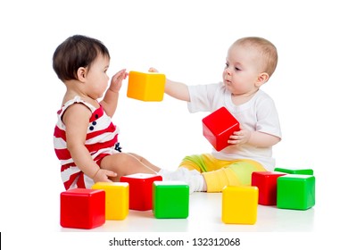 two babies or kids playing together with color toys
