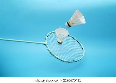 Two badminton shuttlecock and badminton racket on blue background