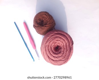 Two balls of different colored knitted yarn and knitting needles