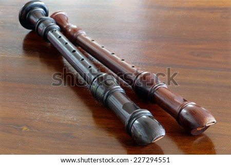 two baroque recorders, musical instruments made of wood, on a wooden table