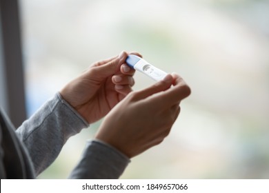 Two bars. Close up of woman hands holding positive home pregnancy test, confused female meeting unexpected gestation thinking making difficult choice, happy lady receiving news of awaited maternity