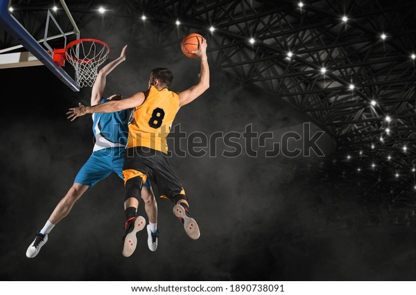 Two\
basketball players in action in arena. Blocked\
shot