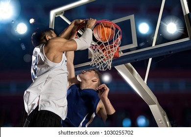 Two basketball players in action in gym
