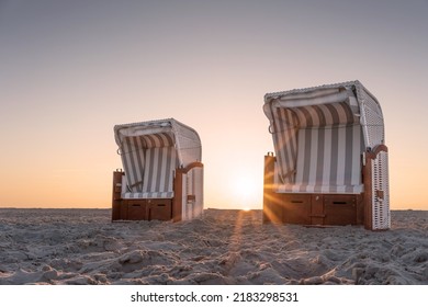 Two Beach Chairs By The Sea In Sunset