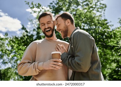 Two bearded men, a gay couple, share a laugh while enjoying a coffee together in a lush green park. - Powered by Shutterstock